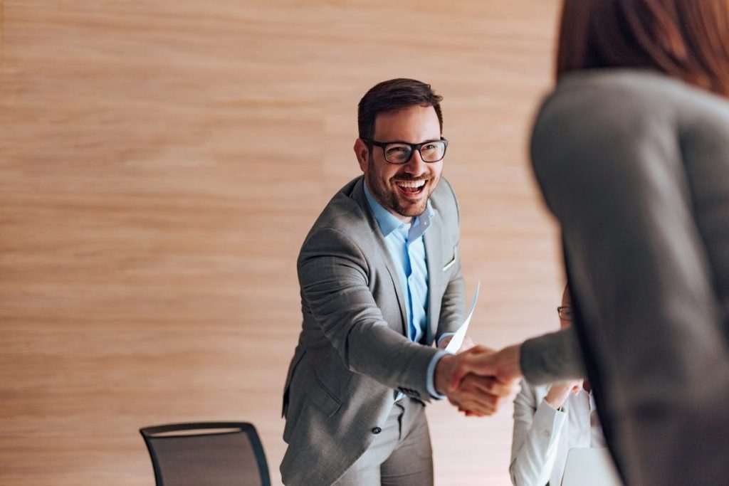 Cheerful businessman greeting job applicant