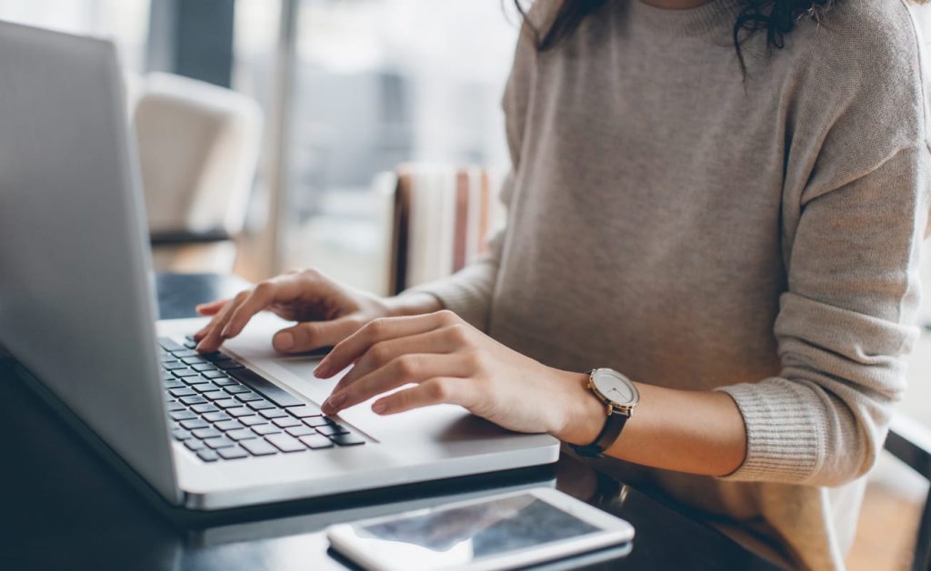 Woman writing a follow up e-mail on her laptop