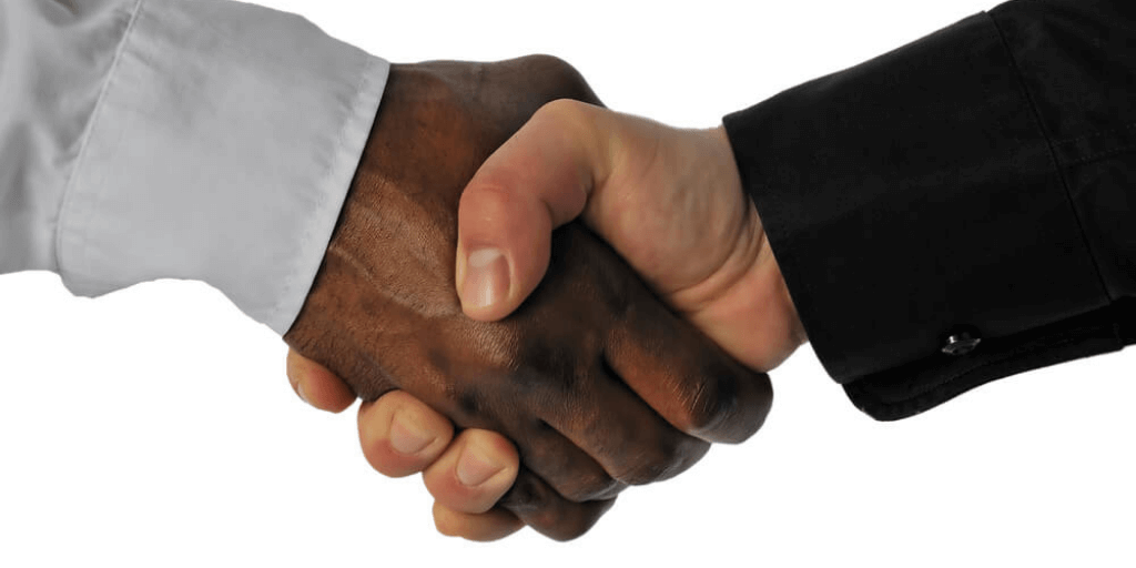 friendly handshake between a white and an african-american businessman as a sign to end racism in the workplace