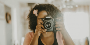 A woman enjoying her polaroid camera as she exemplifies how to answer the what do you like to do for fun interview question