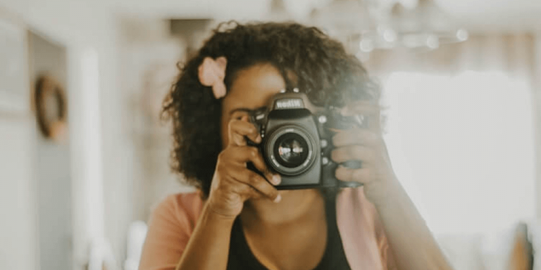 A woman enjoying her polaroid camera as she exemplifies how to answer the what do you like to do for fun interview question